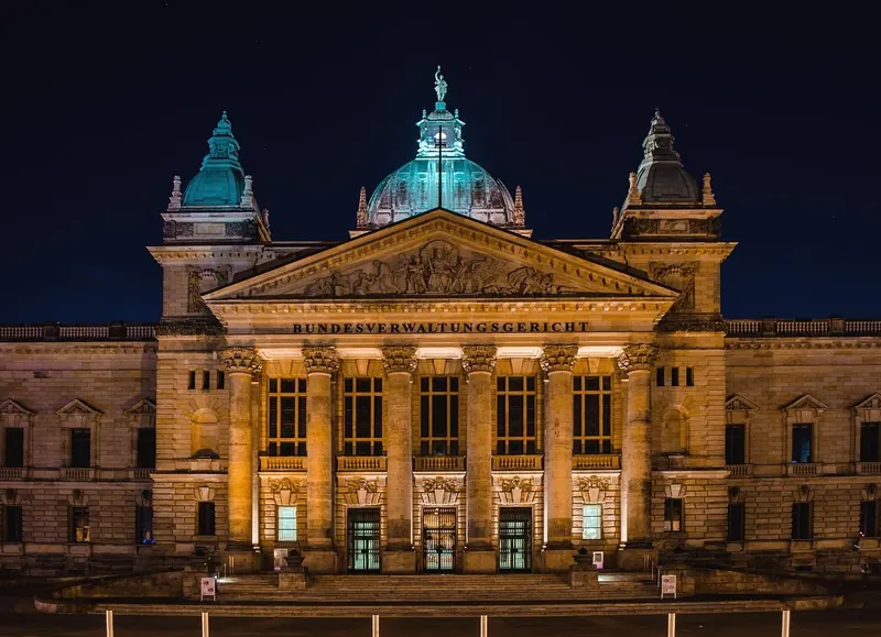 Symbolbild: Das Bundesverwaltungsgericht in Leipzig bei Nacht mit Schriftzug über dem Säulenportal